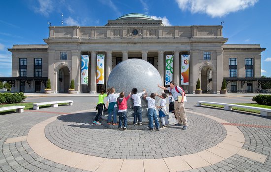 Group of kids touching the Kugel ball.