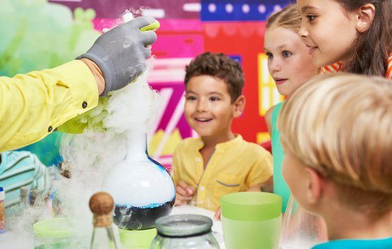 Kids crowded around a science experiment.